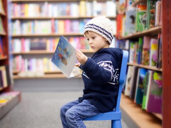 Child reading book in library