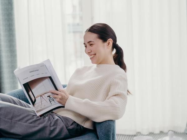 woman reading magazine at home