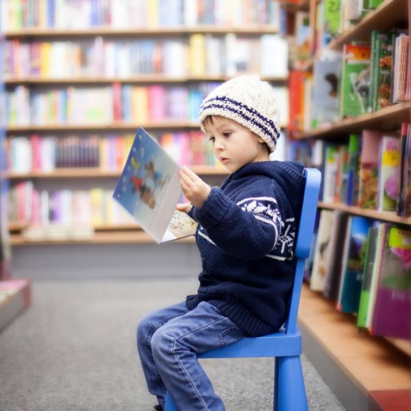 Child reading book in library