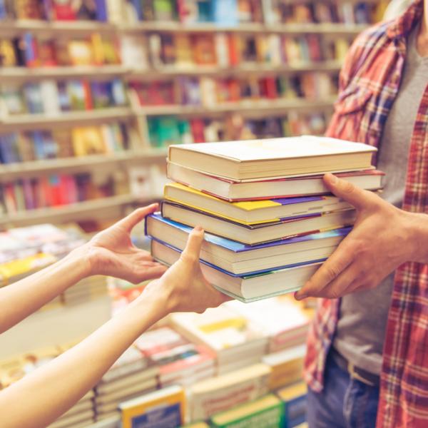 Woman handing books to customer at independent bookstore