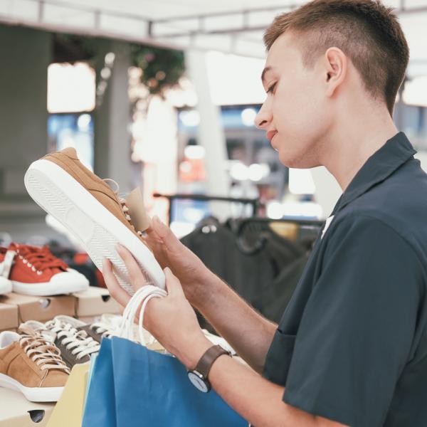 man touching shoe at store