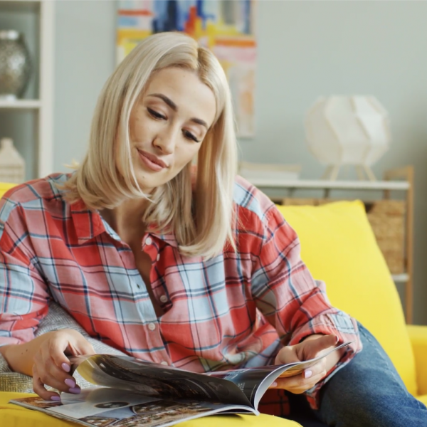 Blonde woman reading magazine at home