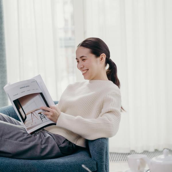 woman reading magazine at home