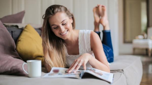 woman on sofa reading magazine