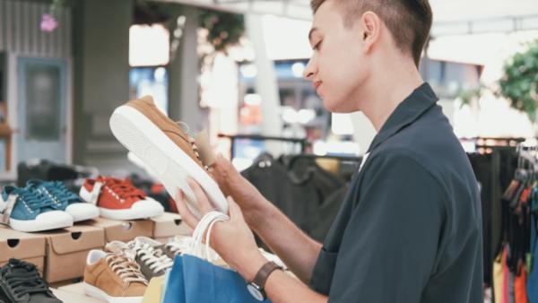 man touching shoe at store