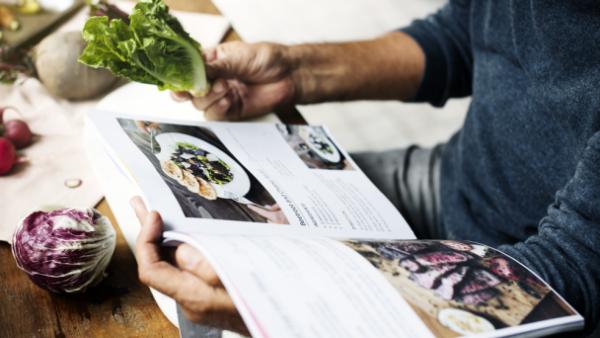 man looking at cookbook