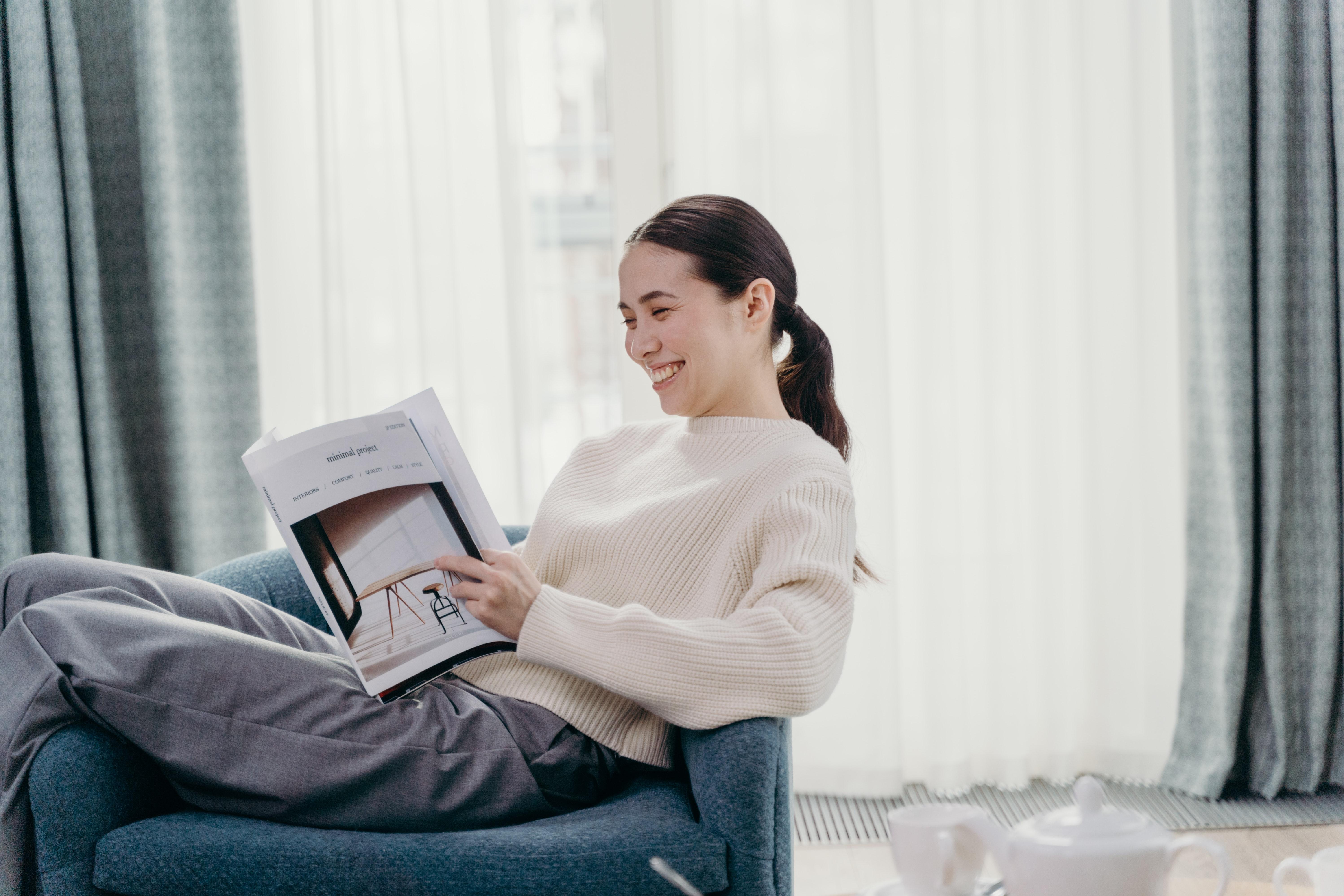 woman reading magazine at home